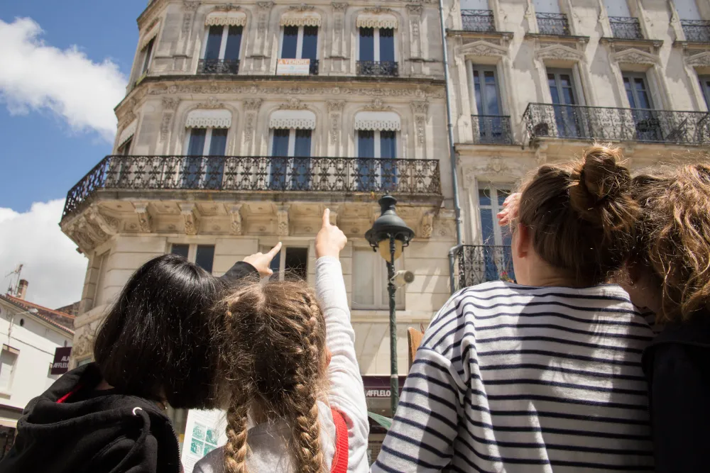 Enfants observant un bel immeuble rochefortais