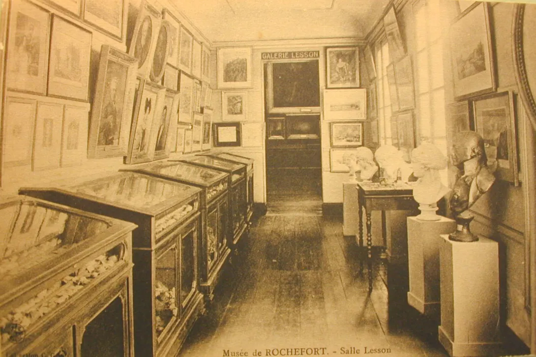 Photo d'archive Salle d'exposition avec de nombreux tableaux et des vitrines
